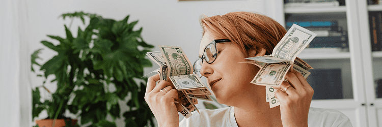Vrouw houdt geld voor haar gezicht